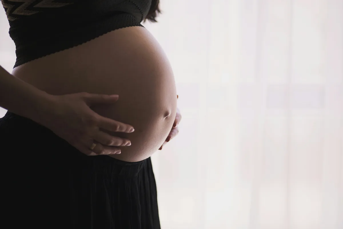 Pregnant woman cradling her belly — pregnancy weight gain guidance